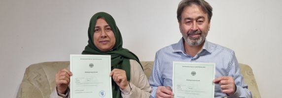 Mervat und Mahmoud halten endlich ihre Einbürgerungsurkunden in den Händen